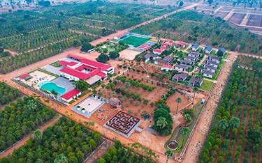 Explore the best places to invest in Hyderabad real estate with an aerial view of the resort area at USM Infra Go Ranch Sandalwood Farm. Discover luxury living surrounded by nature.